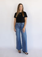 Woman wearing Z Supply The Stunner Mid Rise Wide Leg jeans in Element, a vintage medium wash