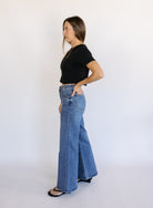 Woman wearing Z Supply The Stunner Mid Rise Wide Leg jeans in Element, a vintage medium wash