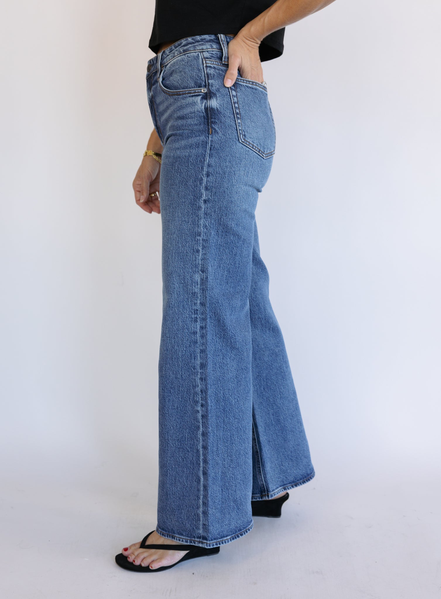 Woman wearing Z Supply The Stunner Mid Rise Wide Leg jeans in Element, a vintage medium wash