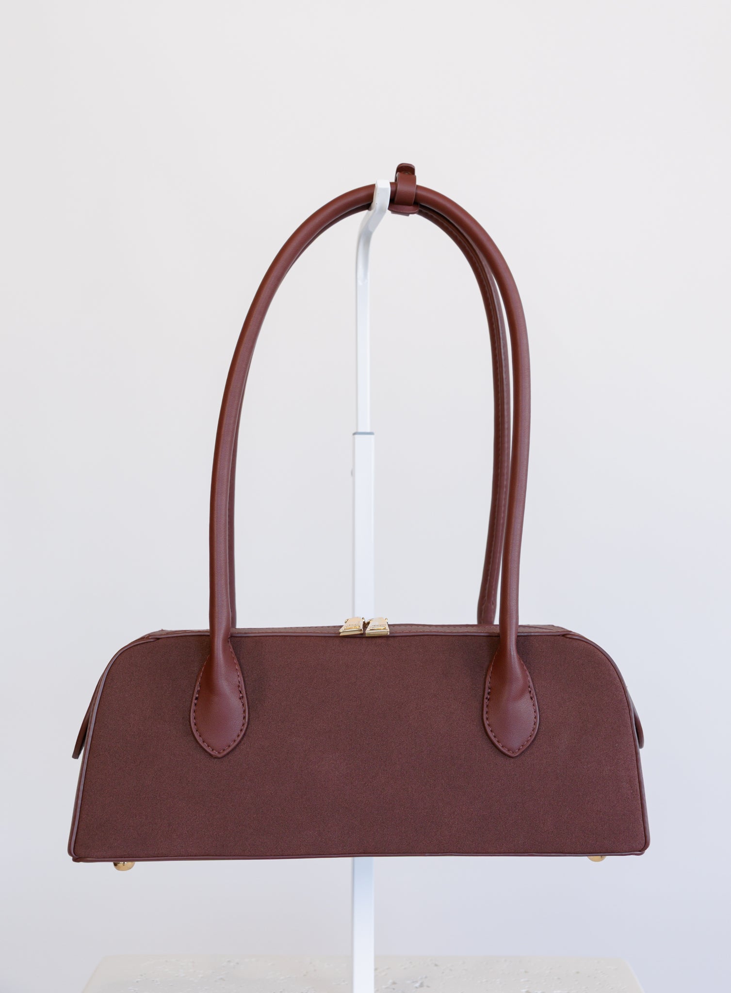 Jonava Suede Bag in Garnet, a deep garnet elongated suede shoulder bag with gold zipper pulls