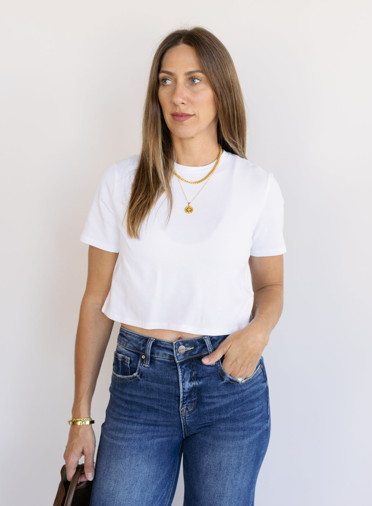 Woman wearing Favorite Daughter The Laura Crop Top in White, a fitted cropped crewneck tee