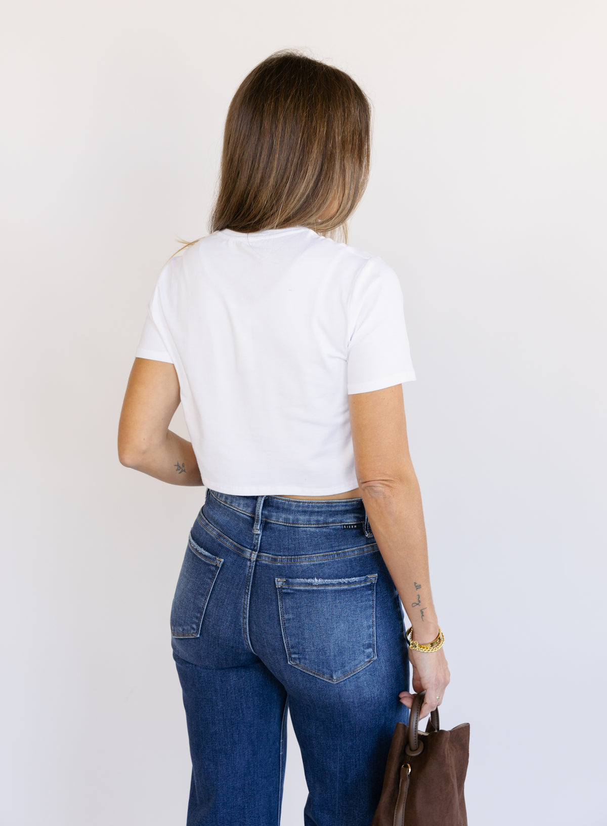 Woman wearing Favorite Daughter The Laura Crop Top in White, a fitted cropped crewneck tee