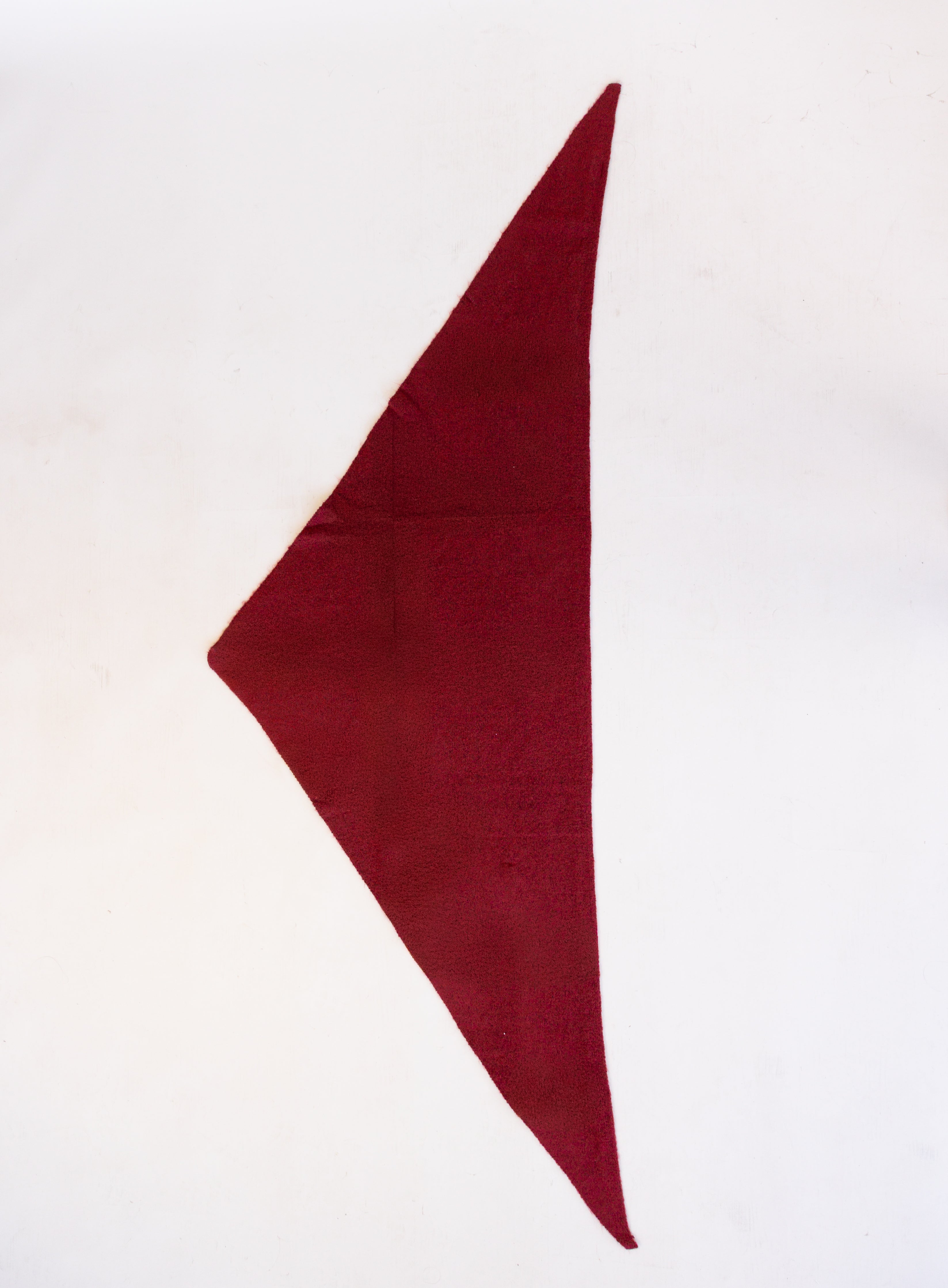 Woman wearing the Wrenley Warm Shawl Scarf in Red, a wine red knit triangle shawl