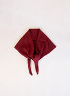Woman wearing the Wrenley Warm Shawl Scarf in Red, a wine red knit triangle shawl