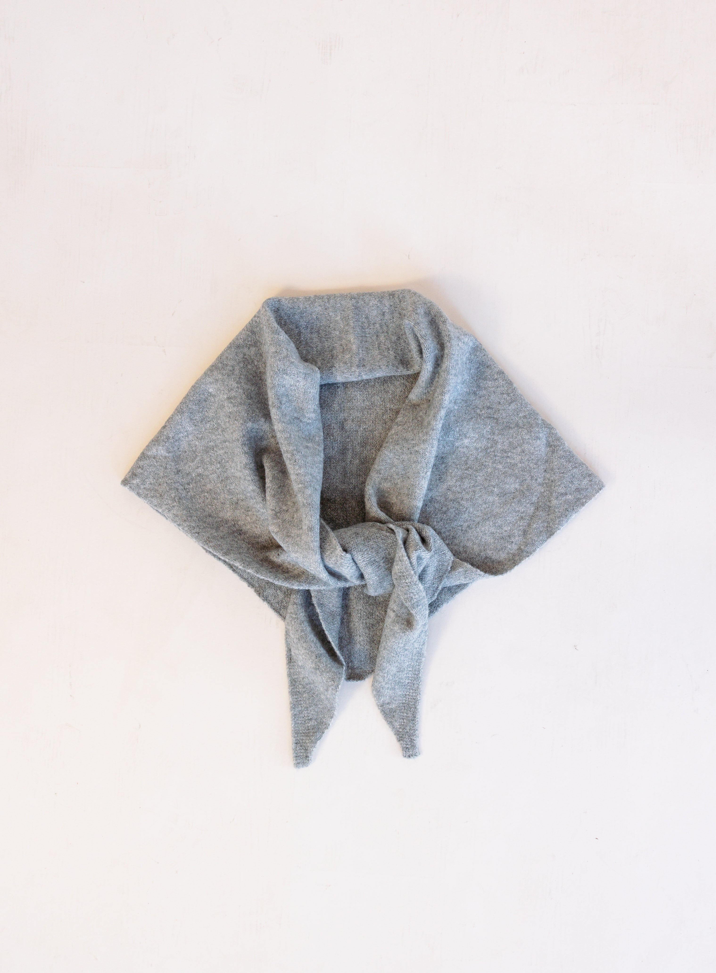 Woman wearing the Wrenley Warm Shawl Scarf in Grey, a heathered grey knit triangle shawl