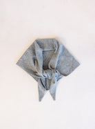 Woman wearing the Wrenley Warm Shawl Scarf in Grey, a heathered grey knit triangle shawl